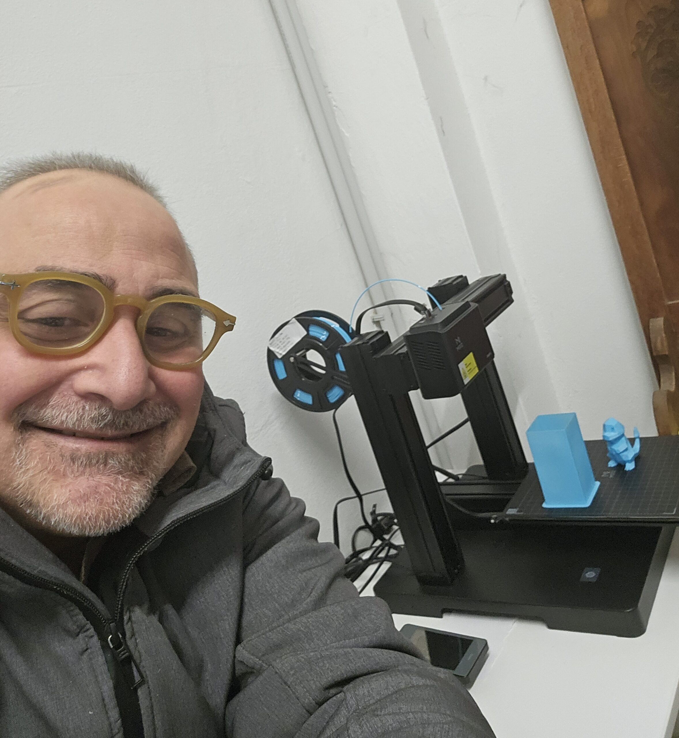 Giancarlo sorride in un selfie. Porta gli occhiali ed è in aula