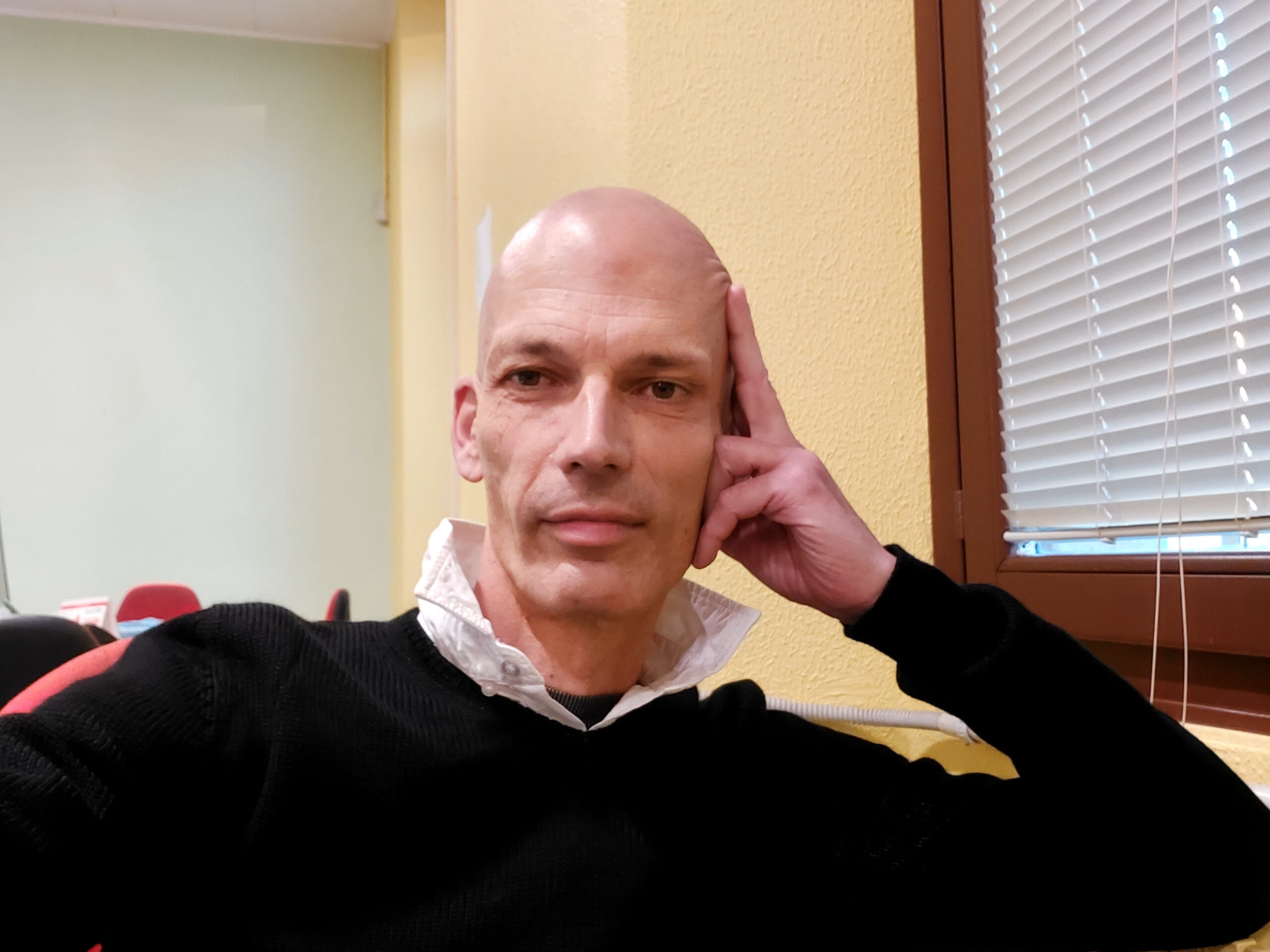 Beppe guarda in camera in una foto a mezzo busto. Ha la testa appoggiata sulla mano sinistra.