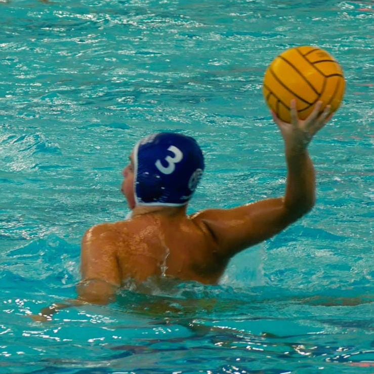 Francesco mentre gioca a pallanuoto. Ha il pallone in una mano e sta per lanciare