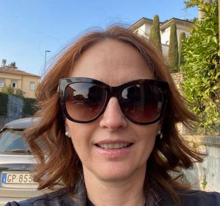 Un primo piano di Giuseppina. Ha gli occhiali da sole e una giacca scura, i capelli ondulati.