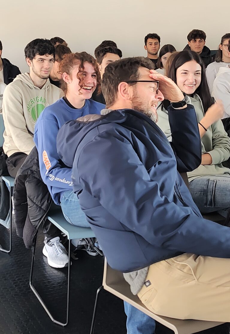 Gruppo di studenti all'Informagiovani. Stanno ridendo insieme al loro docente.