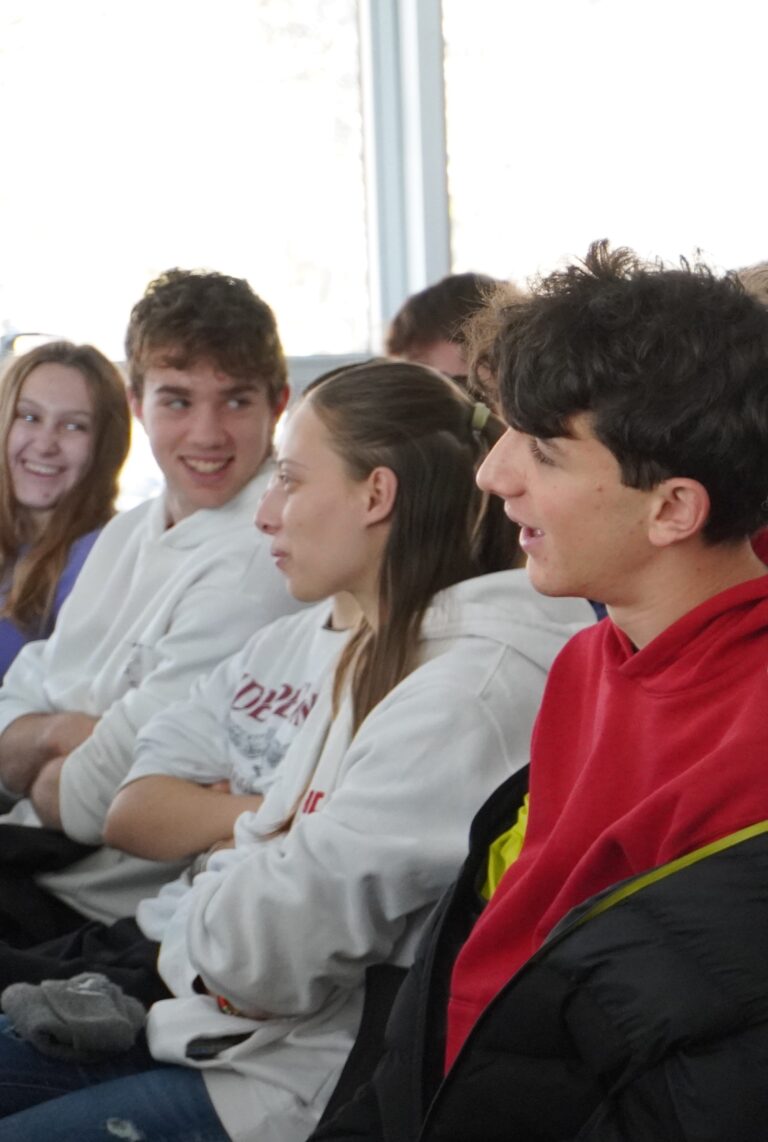 gruppo di studenti durante l'intervento della giornata del placemnt all'Informagiovani. Stanno ridendo. In primo piano una persona con capelli scuri e felpa rossa.
