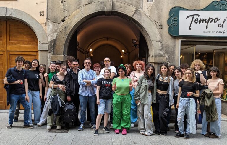 Un gruppo di studenti posa sorridente, guardando in camera. Sono in piedi, disposti in riga.