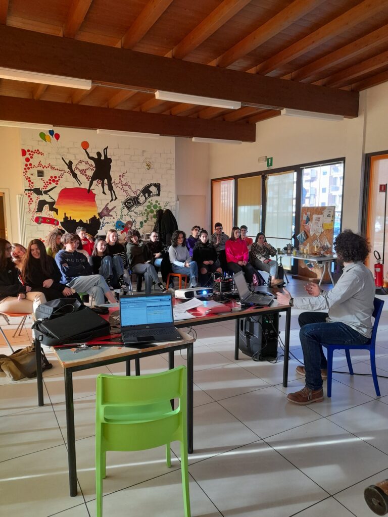 Uno degli educatori del progetto sta tenendo una lezione di fronte a una classe, dentro lo Spazio per Giovani a Boccaleone.