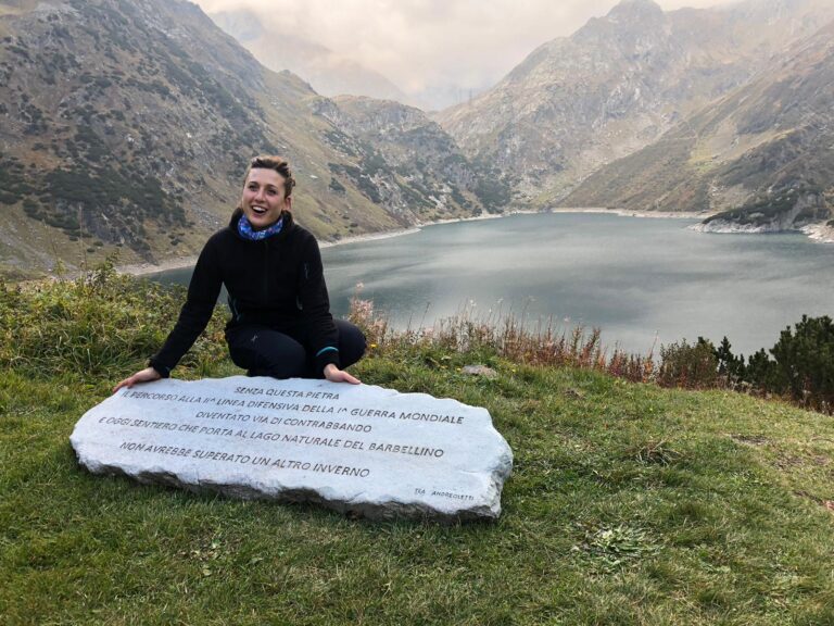 L'artista posa con la sua opera, una lastra di pietra liscia posta di fronte a un lago, con inciso sopra questa frase: 