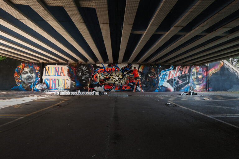 Il murales completo realizzato sotto il viadotto di Boccaleone per I volti dei diritti. Raffigura, da sinistra verso destra, i volti di di Berta Caceres, Nina Simone, Fela Kuti e Ilaria Alpi.