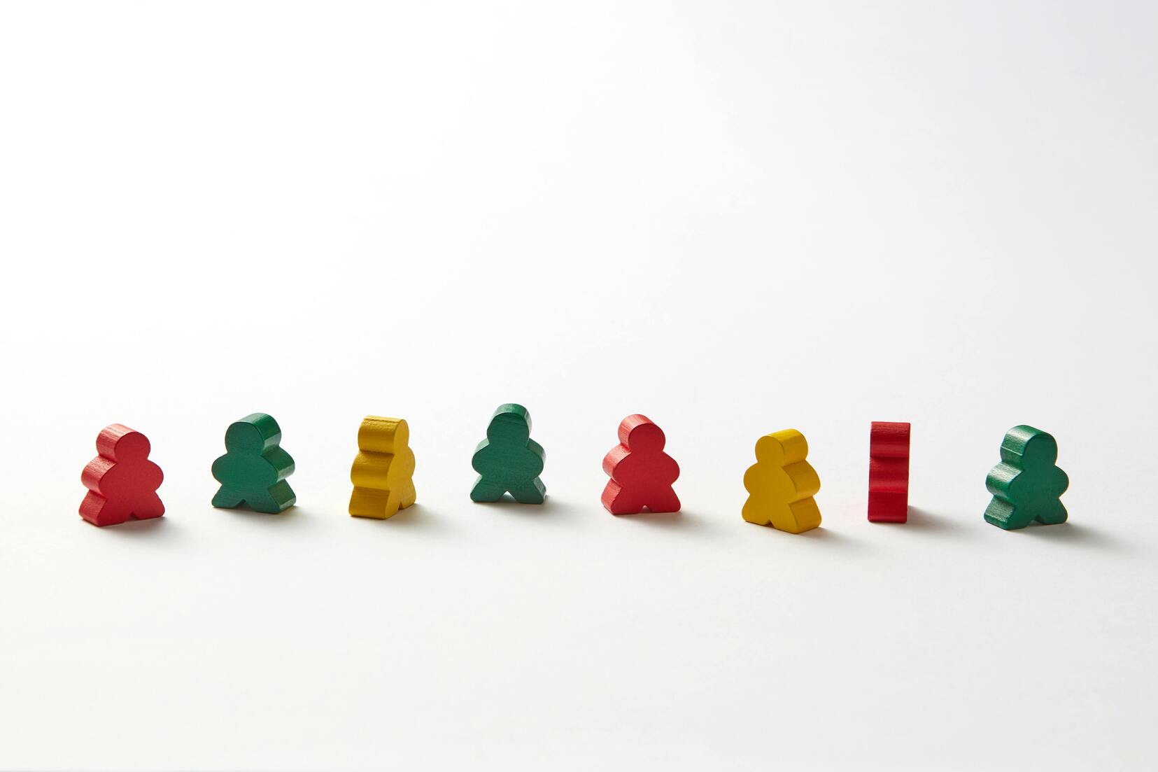 Foto decorativa che ritrae le pedine di un gioco da tavola messe in righe come soldatini.