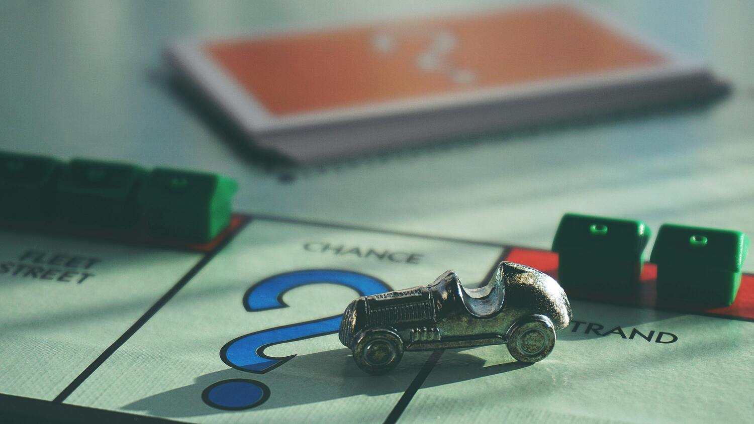 Immagine decorativa: ritrae il dettaglio di una tabellone del Monopoli con le pedine e le carte degli imprevisti