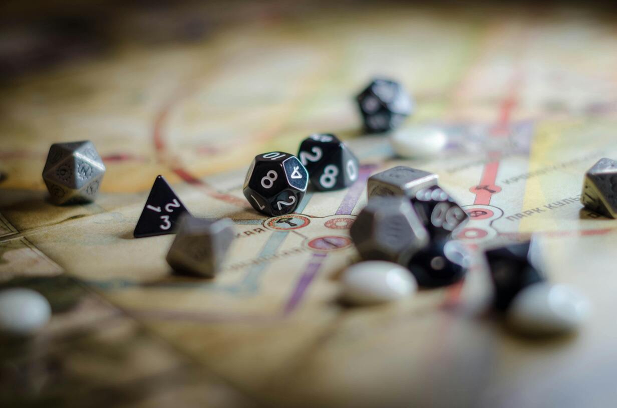 Immagine decorativa che ritrae il tabellone di un gioco da tavola con tanti dadi di forme e tipi diversi.