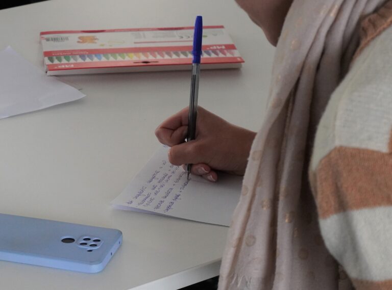 Immagine di persona che scrive. Si vede solo la mano e un foglio