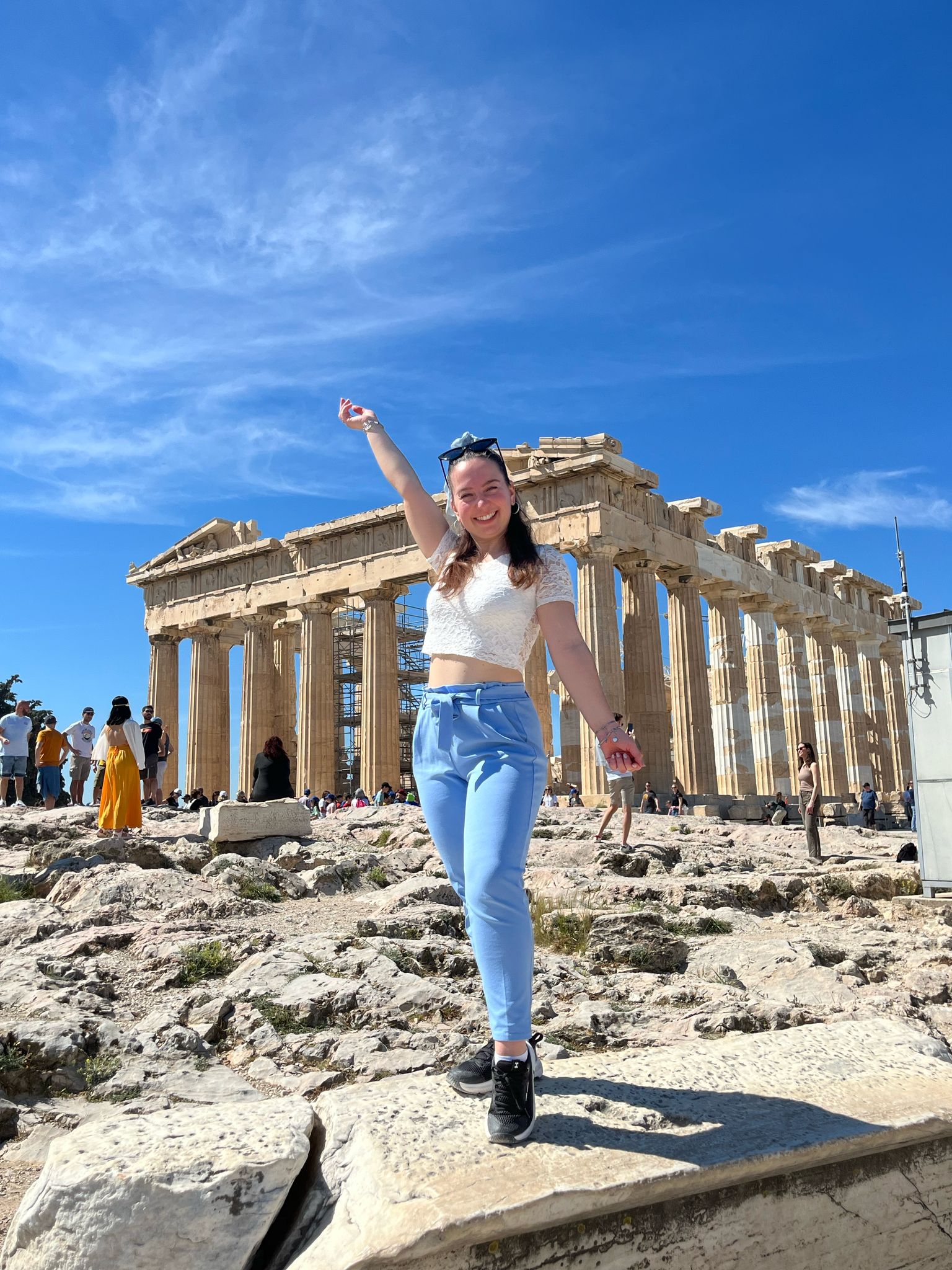 Ingrid di fronte alle rovine del Partenone di Atene, indossa una maglietta bianca e dei jeans.