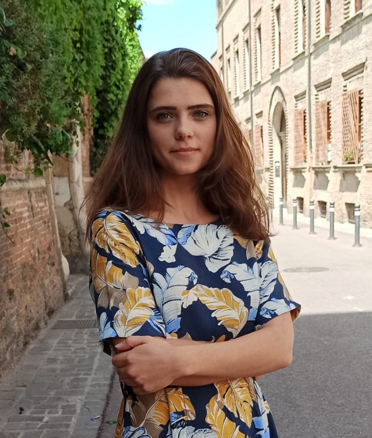 Primo piano di Mihaela con indosso un abito floreale.