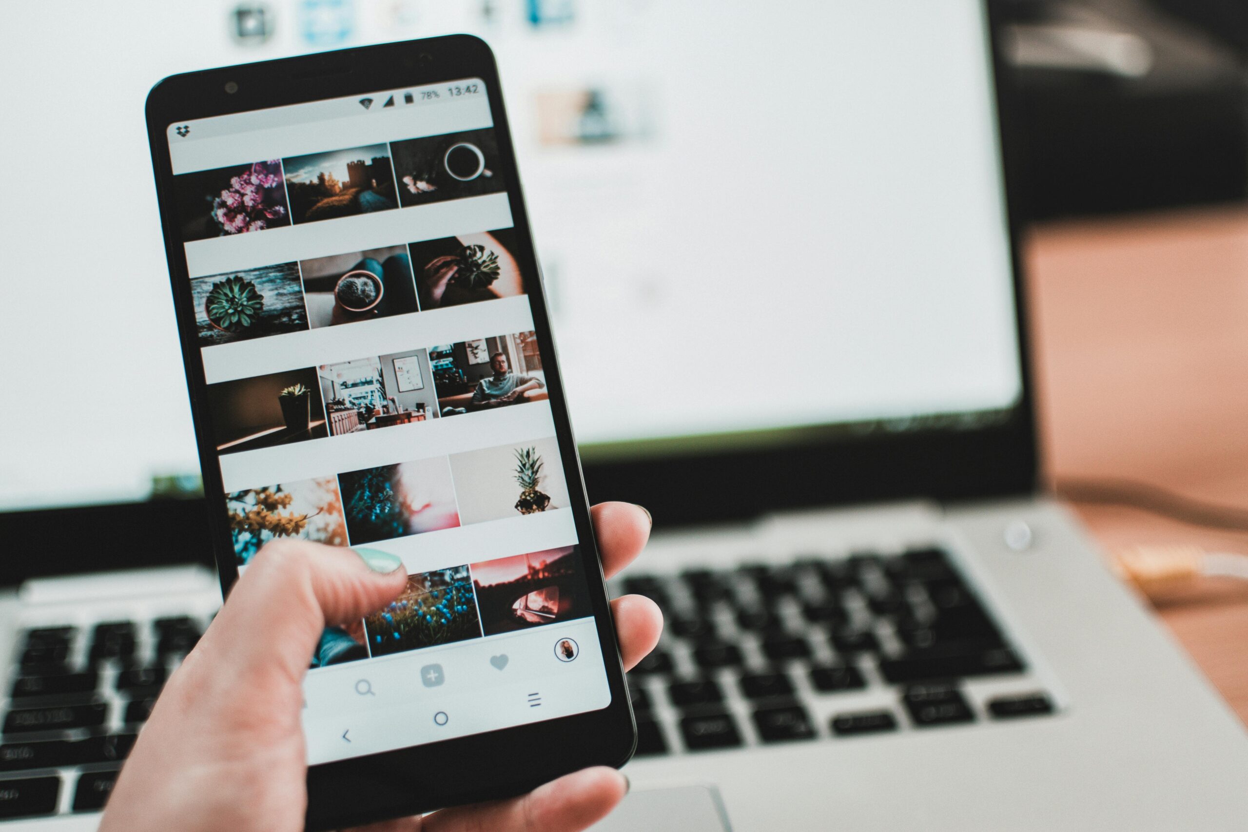 Immagine con telefono e computer, il telefono è aperto sulla galleria foto