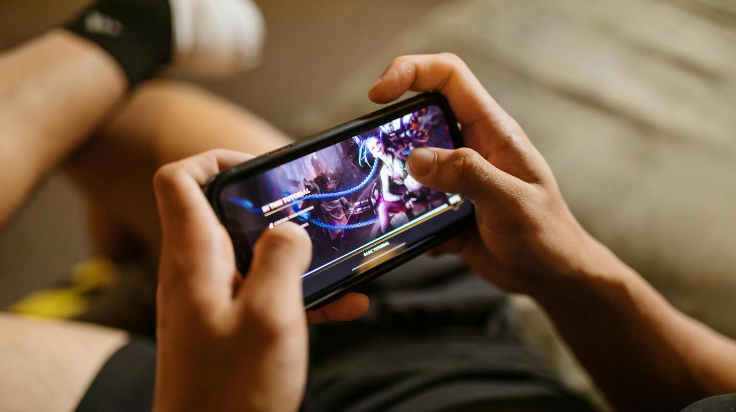 Primo piano sulla schermata di videogioco per smartphone, a cui sta giocando un ragazzo.