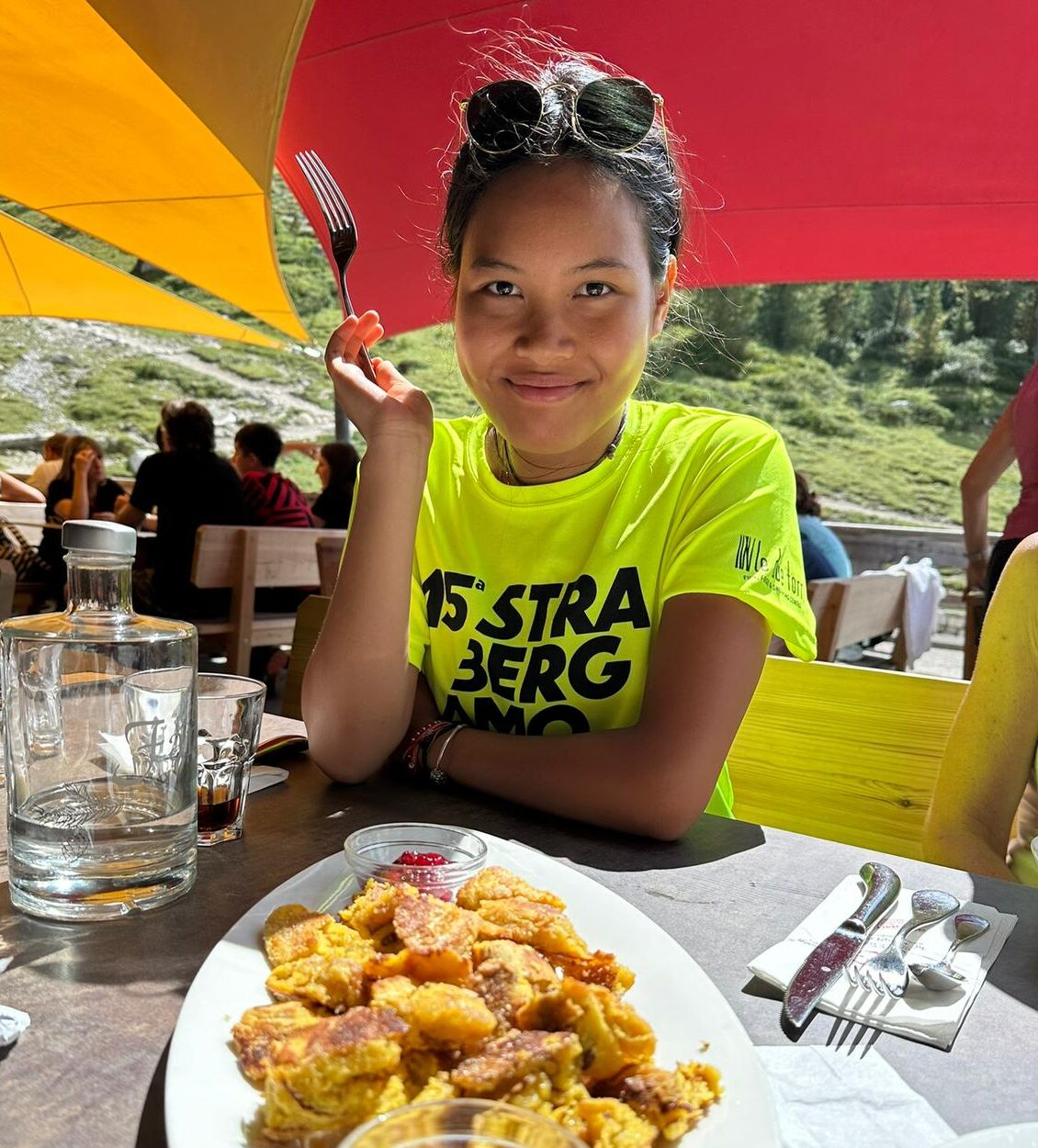 Sara al ristorante. Sorride e indossa una maglietta giallo fluo.