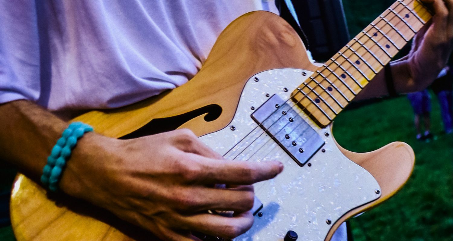 la mano di un chitarrista che sta suonando il suo strumento