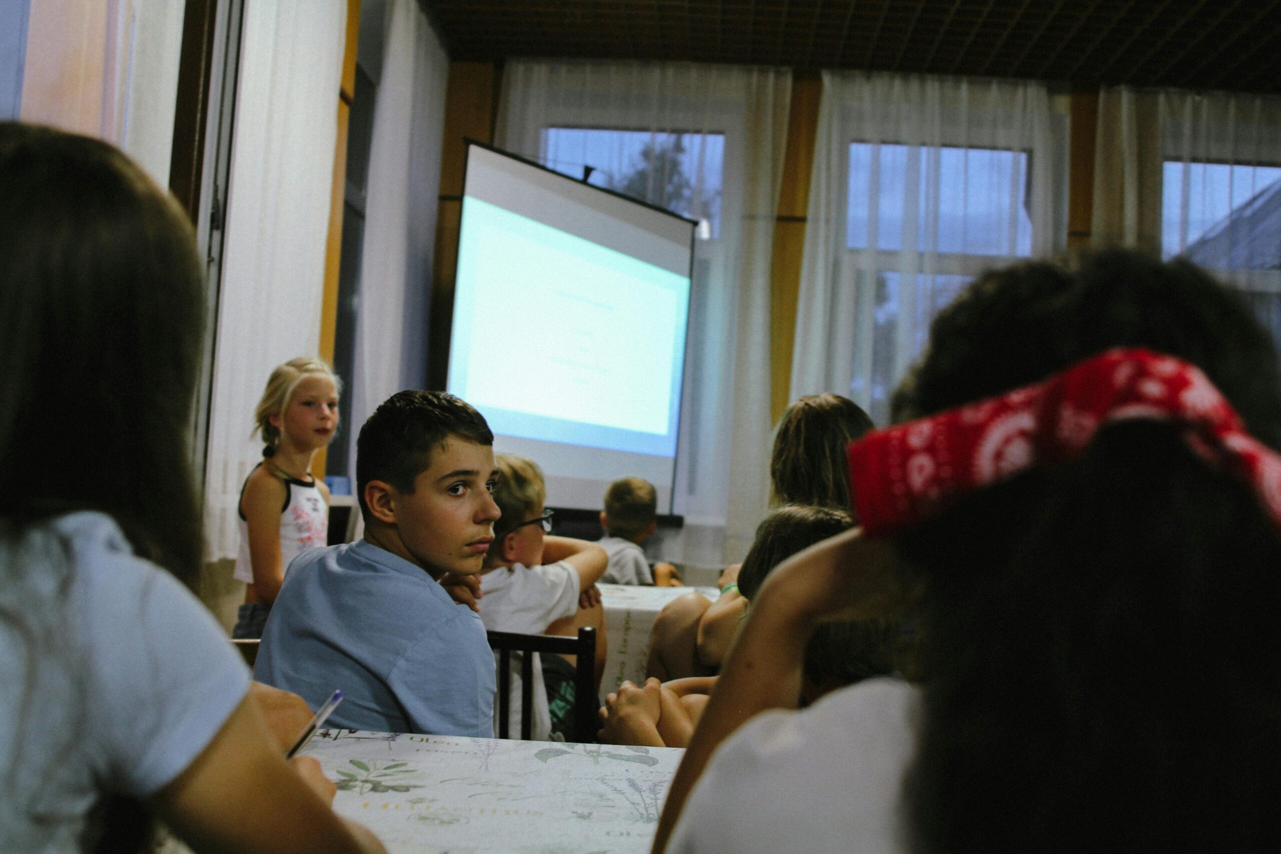 Gruppo di studenti in aula, fotografia ch eritrae il gruppo dal fondo della classe. Davanti al gruppo un telo per proiezioni