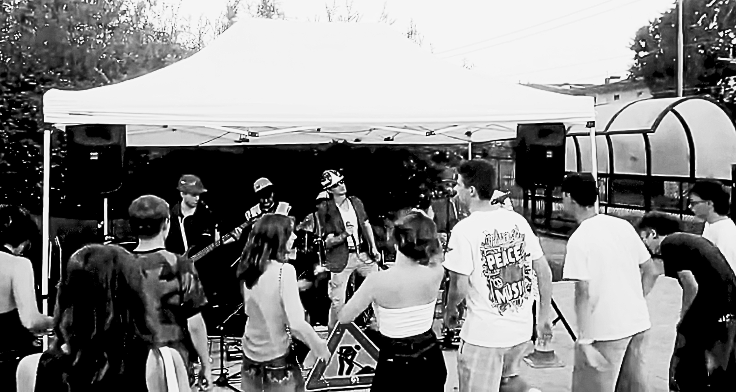 Concerto all’aperto con una giovane band che si esibisce sotto un gazebo davanti al pubblico.